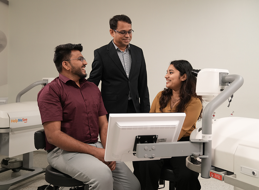 HelpMeSee staff and trainees discuss simulation-based cataract surgery training inside a training center.